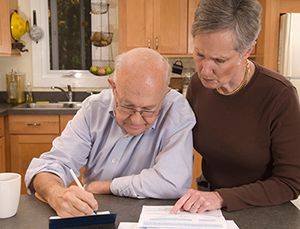 elderly man writing a check