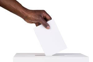 dropping ballot into ballot box