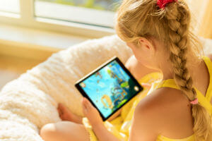 girl playing game on tablet