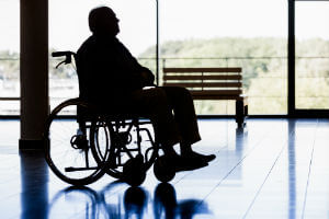 resident sitting in a wheelchair in a dark room