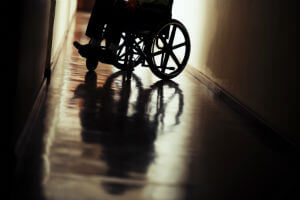 person in wheelchair in darkened hallway