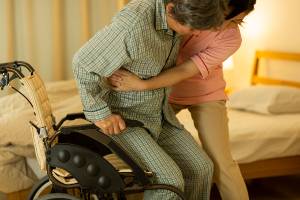 assisting elderly person transferring out of wheelchair