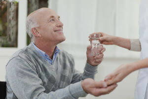nursing home resident holding water glass