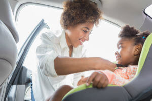 Mother putting child in booster seat