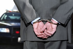 a business man in a suit wearing handcuffs