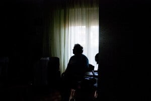 elderly nursing home patient sitting in dark room