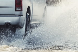 stock image of car driving through heavy rain