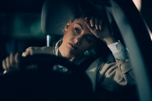 young woman driving drowsy at night