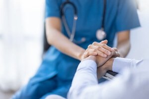 photo illustration of nurse holding a patient's hands