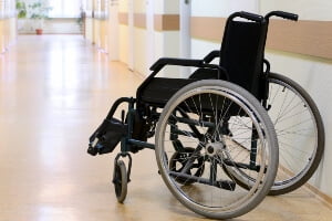 empty wheelchair sitting in hallway of nursing home facility