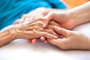 close up image of an elderly woman hand holding her daughter's hand