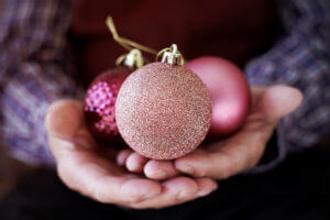 old man holding christmas balls