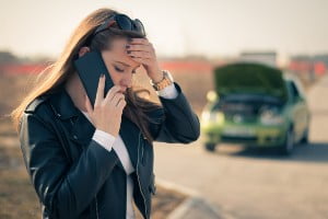 young woman with broken down car