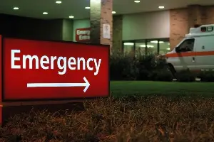 Emergency room sign and ambulance in front of ER entrance