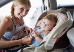 Mother taking care of child on car seat